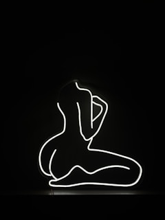 a black and white photo of a person sitting in the dark