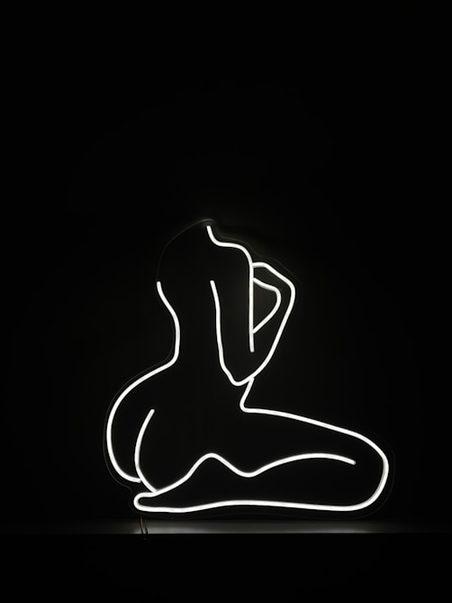 a black and white photo of a person sitting in the dark