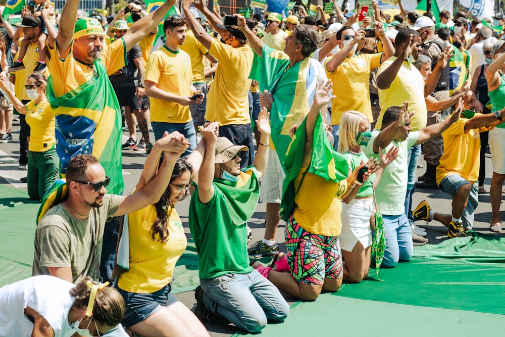 eine große Gruppe von Menschen in gelben und grünen Hemden