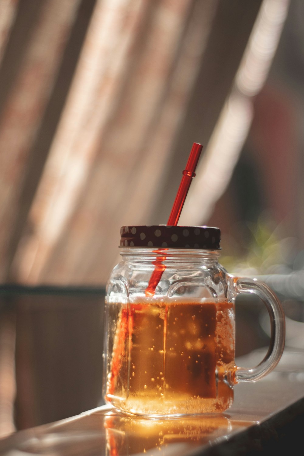 a glass mug filled with liquid and a straw