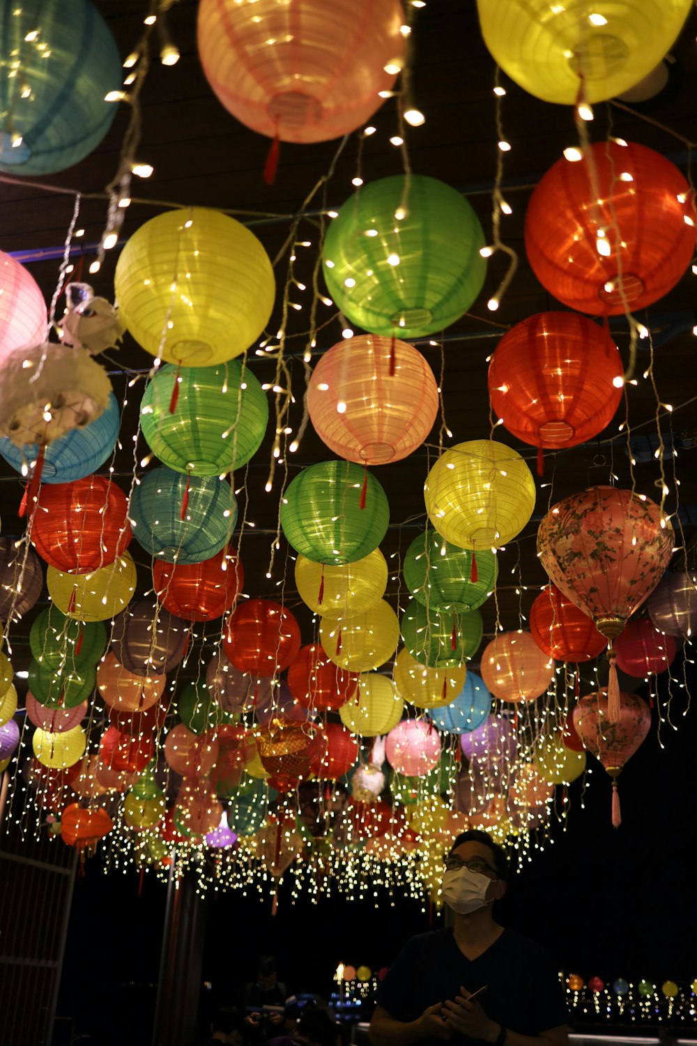 a room filled with lots of colorful paper lanterns