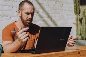 a man sitting at a table using a laptop computer