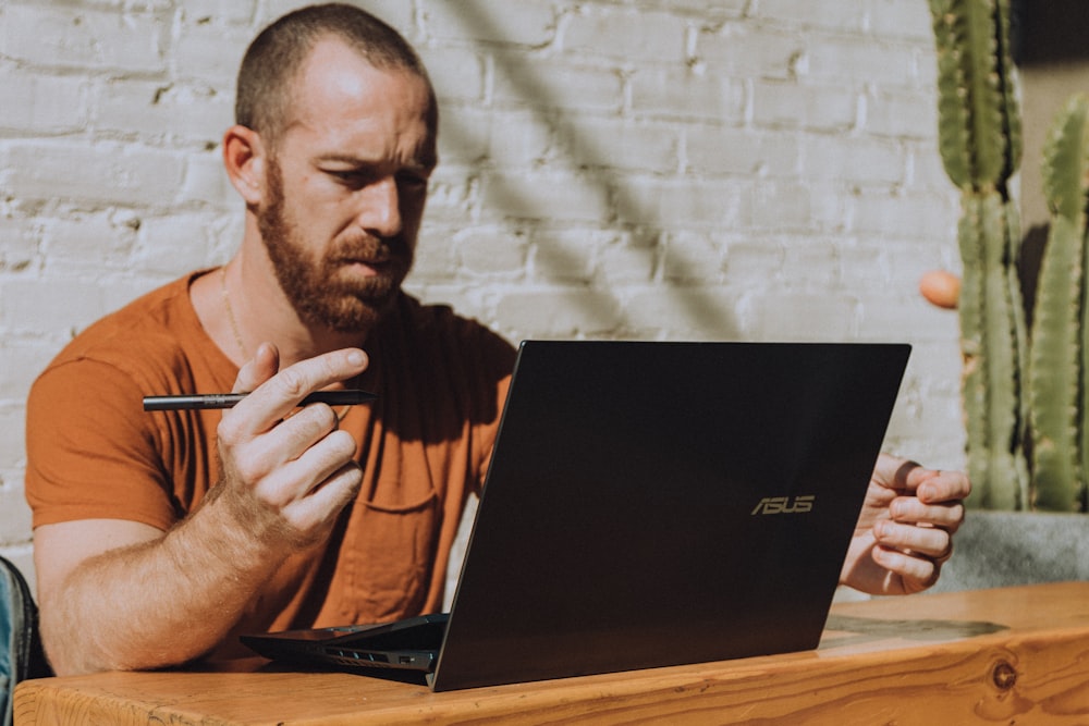 Ein Mann sitzt an einem Tisch mit einem Laptop