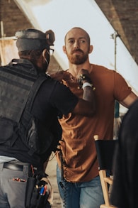 a man in a brown shirt is talking to a man in a brown shirt