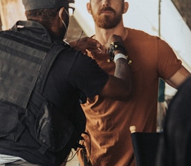 a man in a brown shirt is talking to a man in a brown shirt