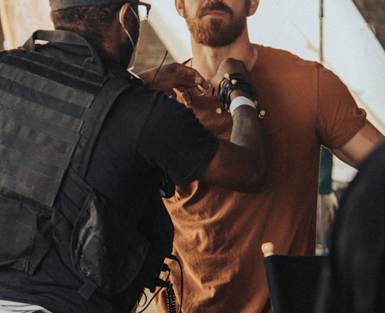 a man in a brown shirt is talking to a man in a brown shirt