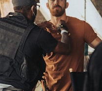 a man in a brown shirt is talking to a man in a brown shirt