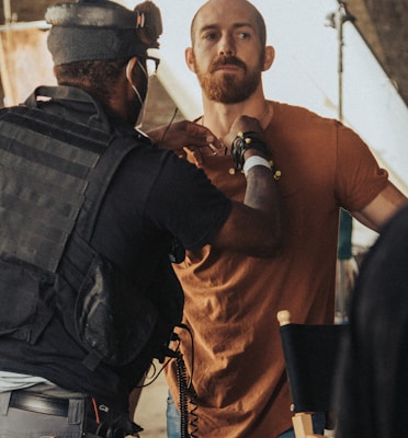 a man in a brown shirt is talking to a man in a brown shirt