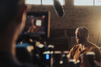 Professional video production setup capturing an interview with a male subject in a cinematic settin