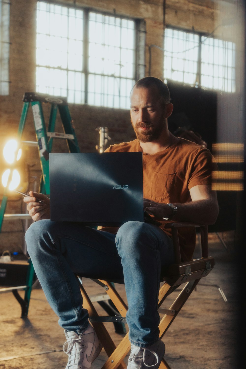 Ein Mann sitzt auf einem Stuhl mit einem Laptop
