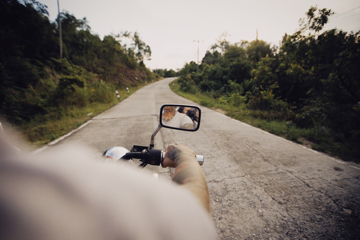 a person riding a motorcycle down a rural road