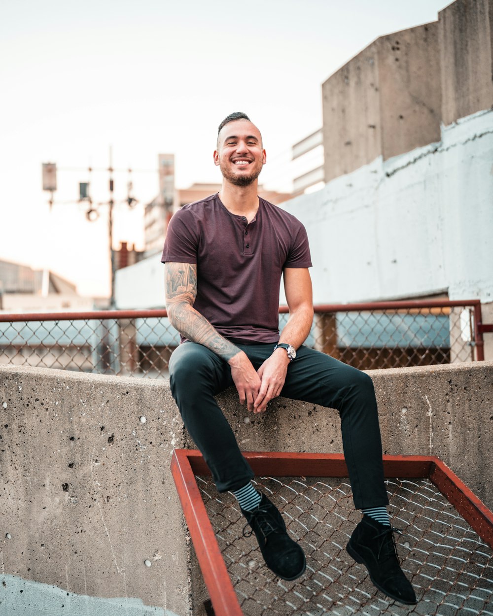 a man sitting on top of a cement wall