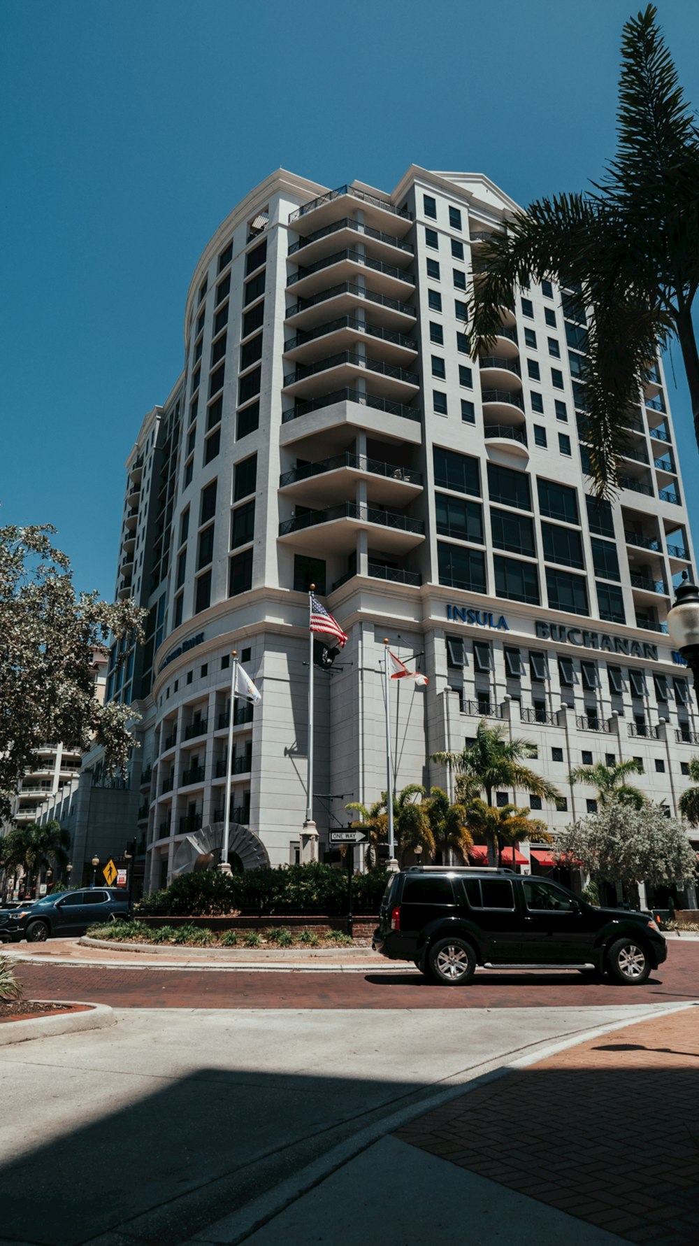 a black truck driving past a tall building