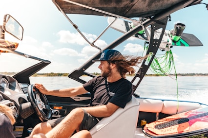 a man driving a boat on a body of water
