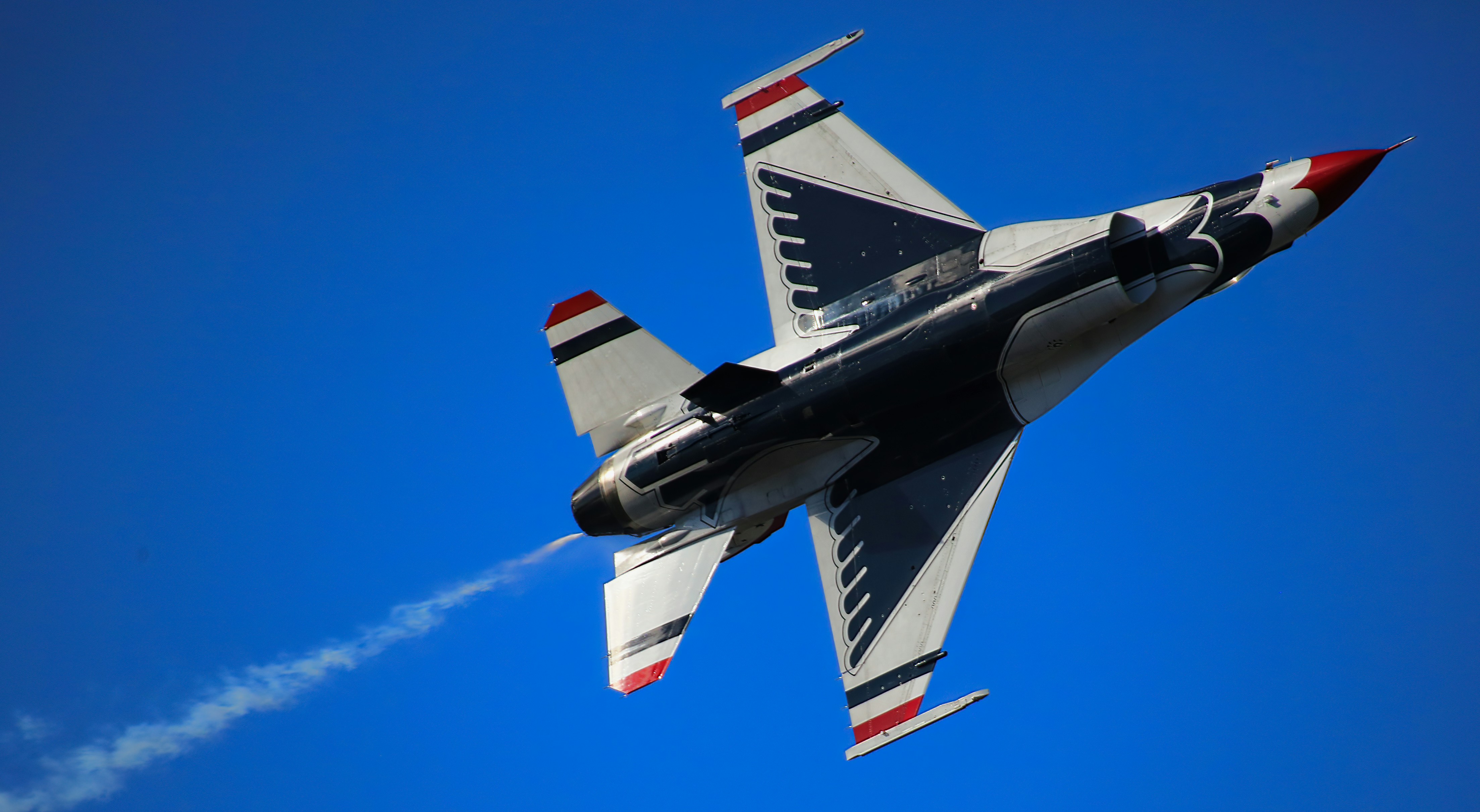 a fighter jet flying through a blue sky, Underbelly