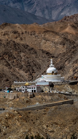 a large white building in the middle of a mountain