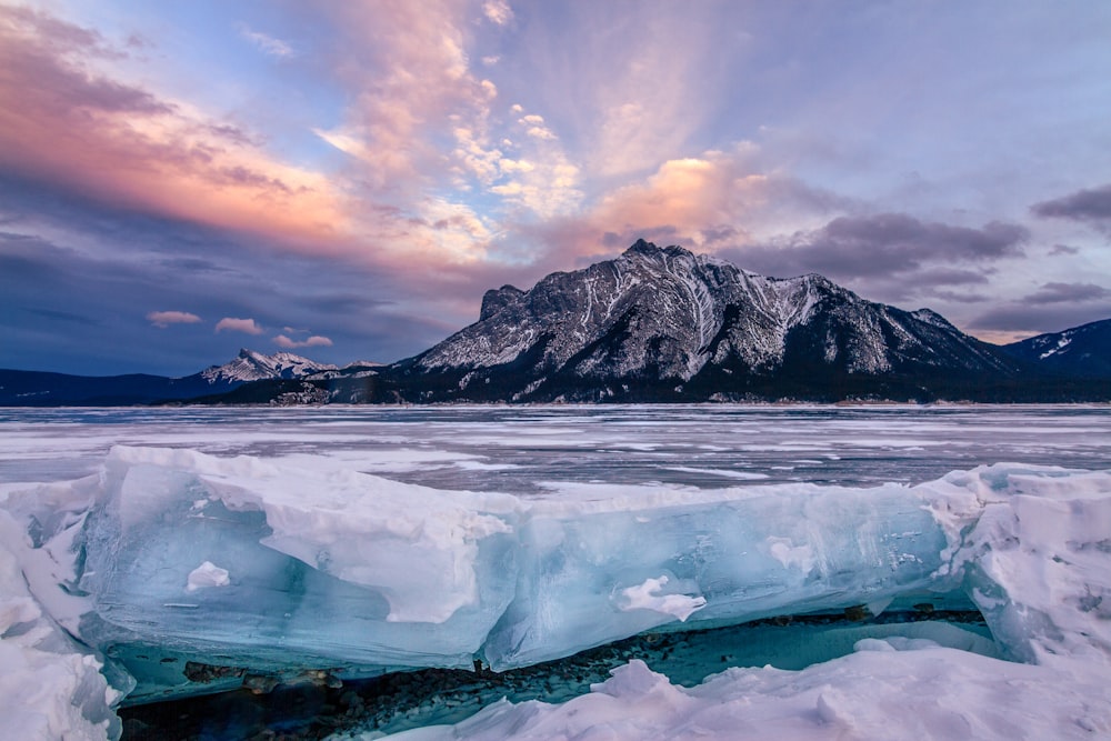 a large iceberg floating on top of a frozen lake