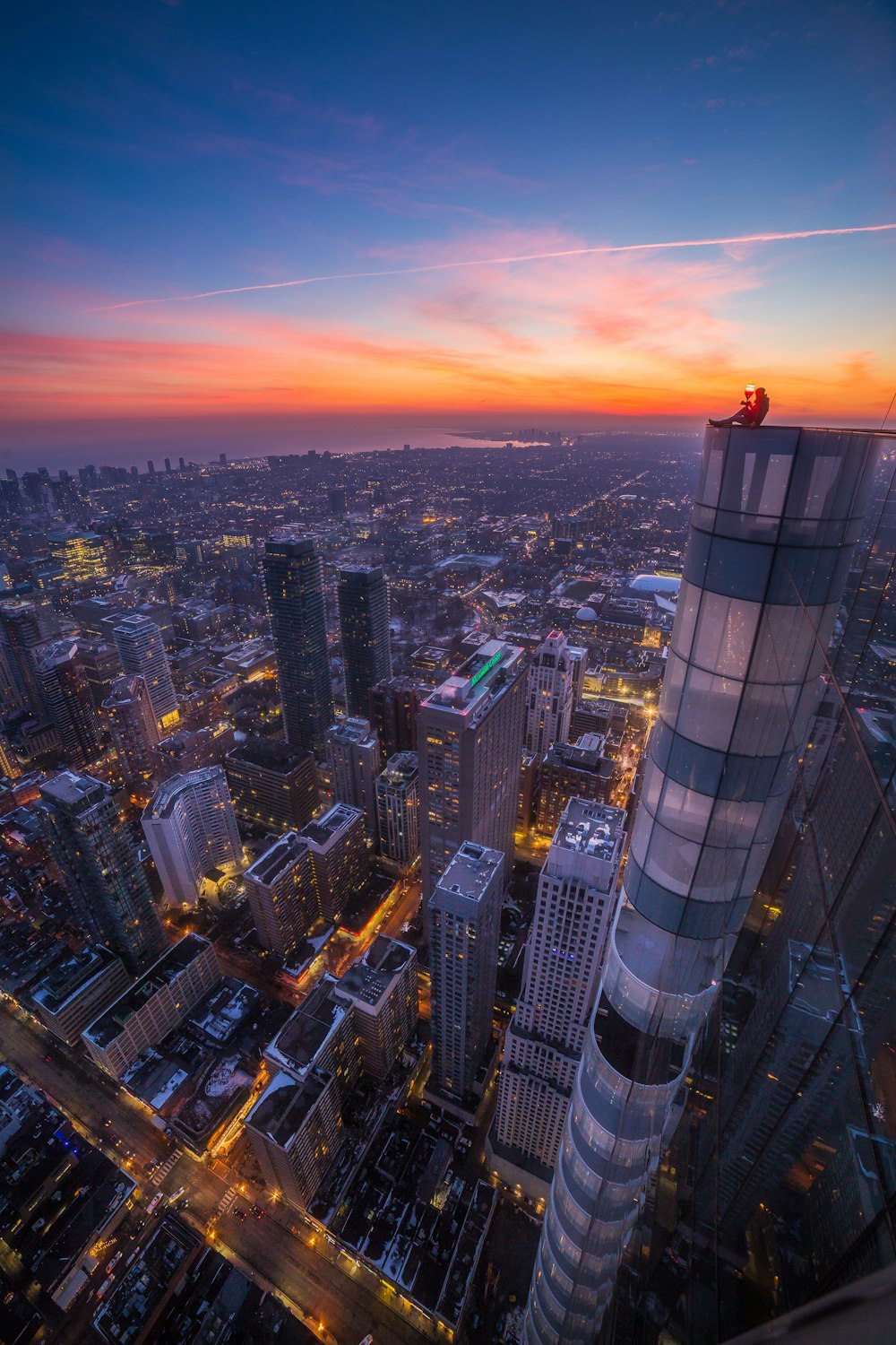 a view of a city at night from the top of a skyscraper