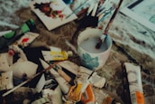 An artist’s workspace with paint tubes, brushes, and unfinished canvas bathed in natural light.
