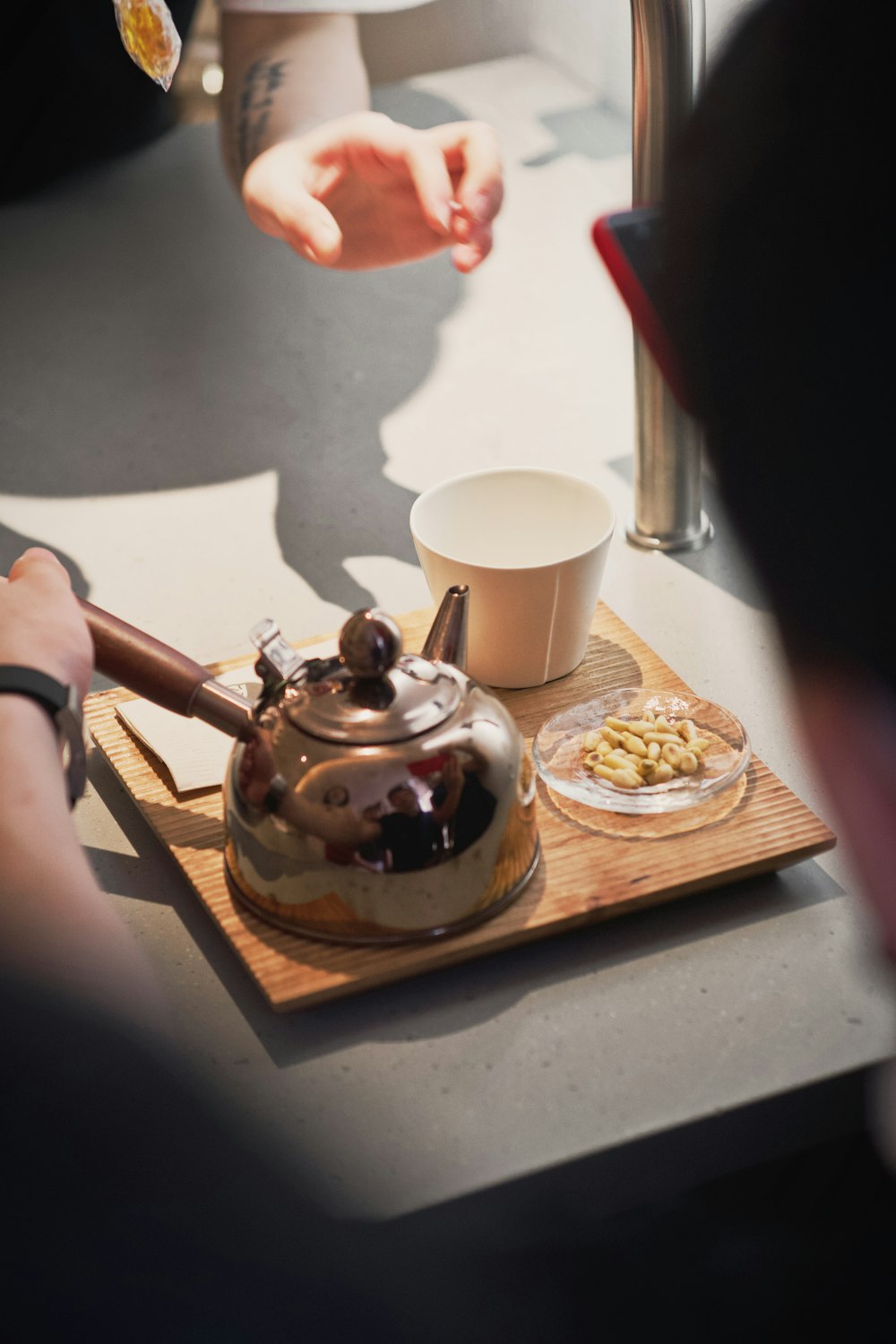 a tea kettle sitting on top of a wooden tray