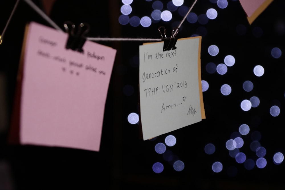 a note attached to a string with lights in the background