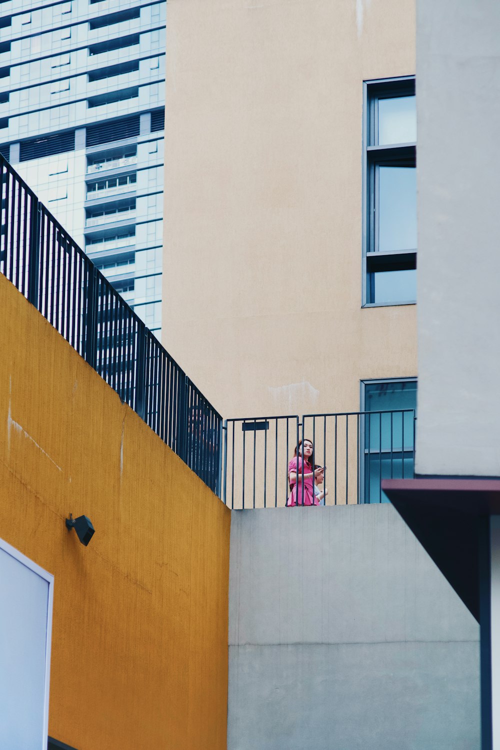 a person standing on a balcony next to a building