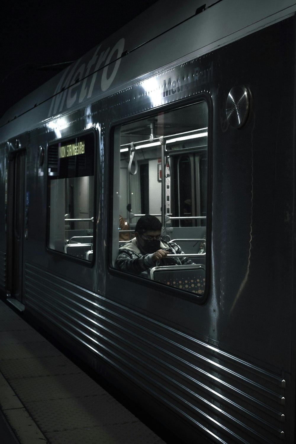 a man is sitting in the window of a train