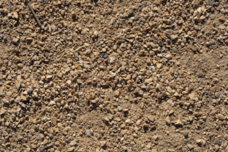 A close-up of various landscaping materials like gravel and sand in a yard.