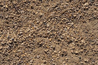 A close-up of various landscaping materials like gravel and sand in a yard.