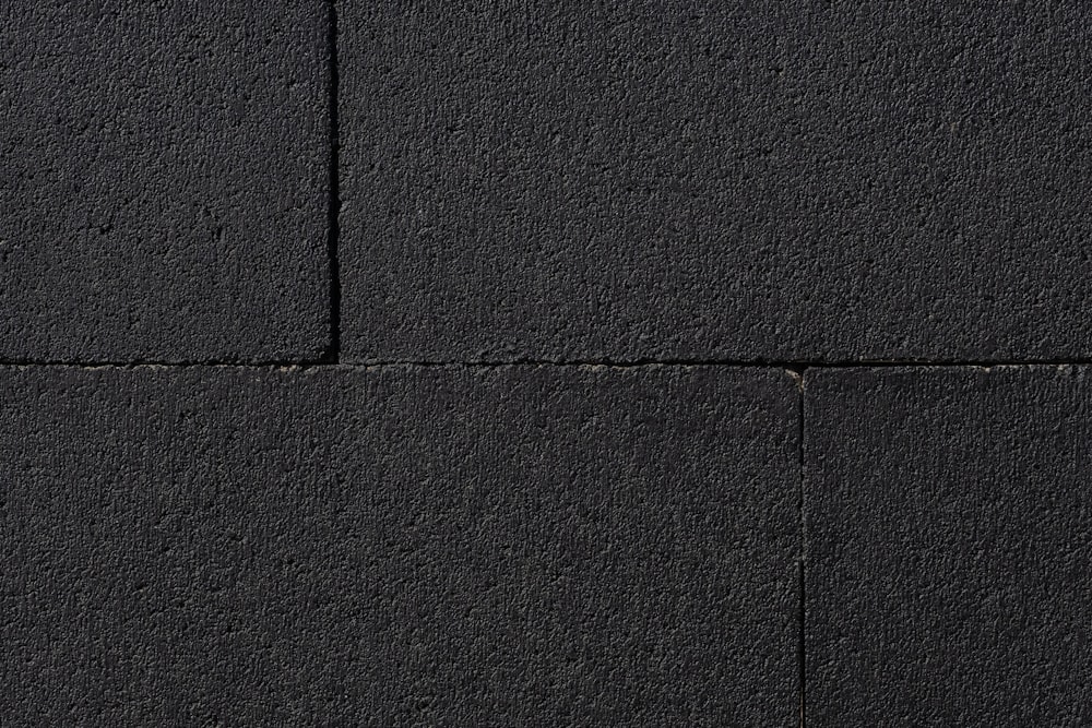 a close up of a black wall with a white object in the middle of it