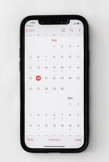 A smartphone displaying a digital calendar for September 2021. The calendar highlights September 20th in red. The interface shows weekdays at the top beginning with Sunday, and options at the bottom for navigation. The time shown on the phone is 1:44.