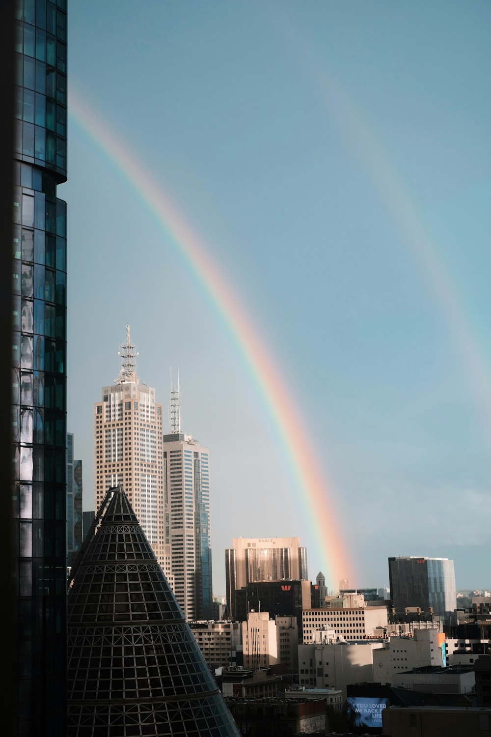 a double rainbow in the sky over a city