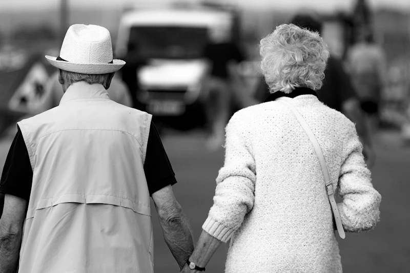 silver singles couple holding hands on a walk