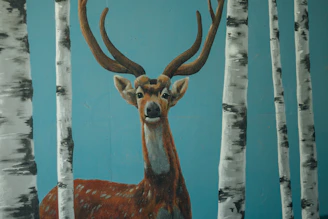 Soft watercolor painting of a deer with mirrored antlers blending into mist.