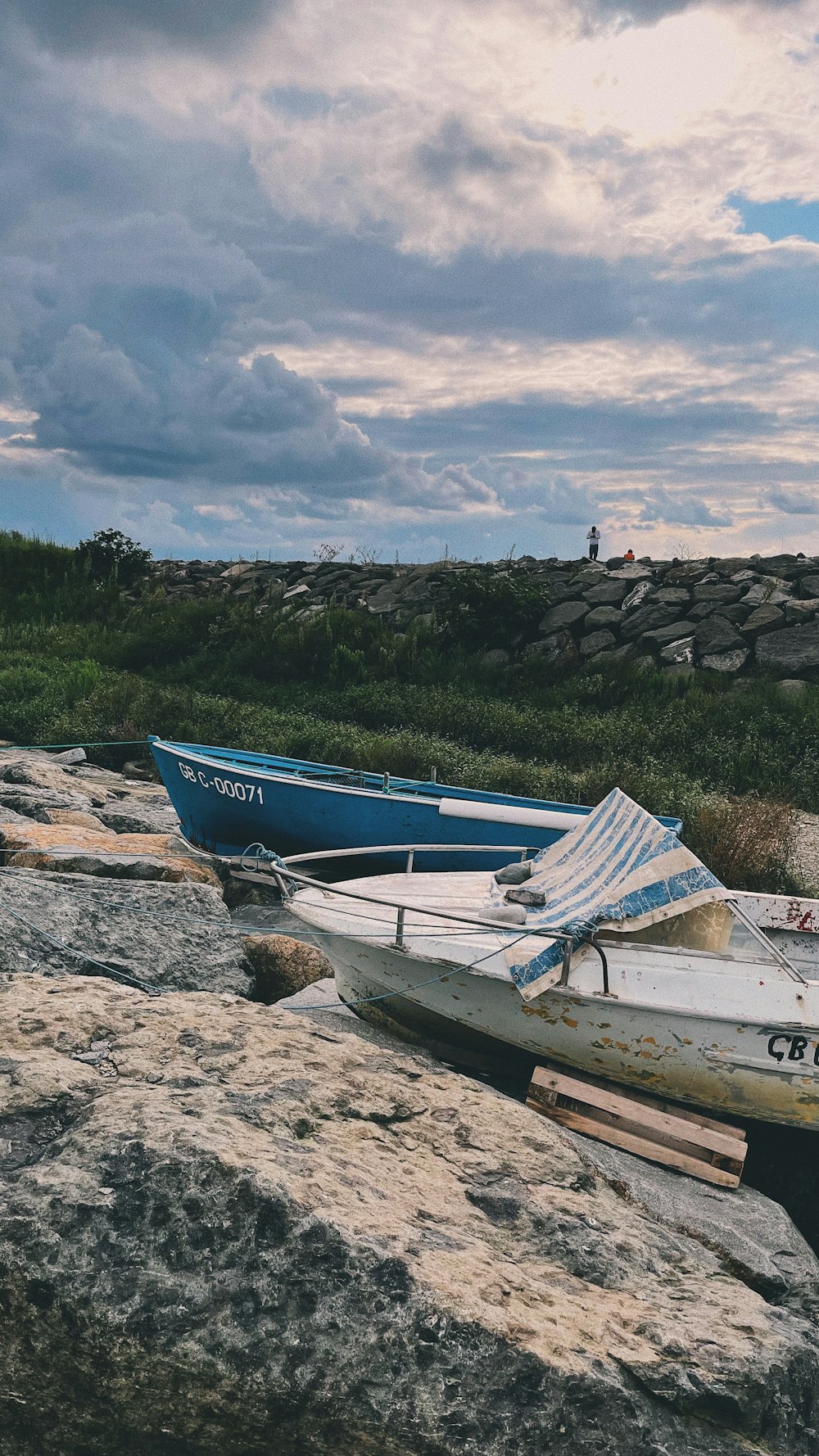 a couple of boats that are sitting on some rocks