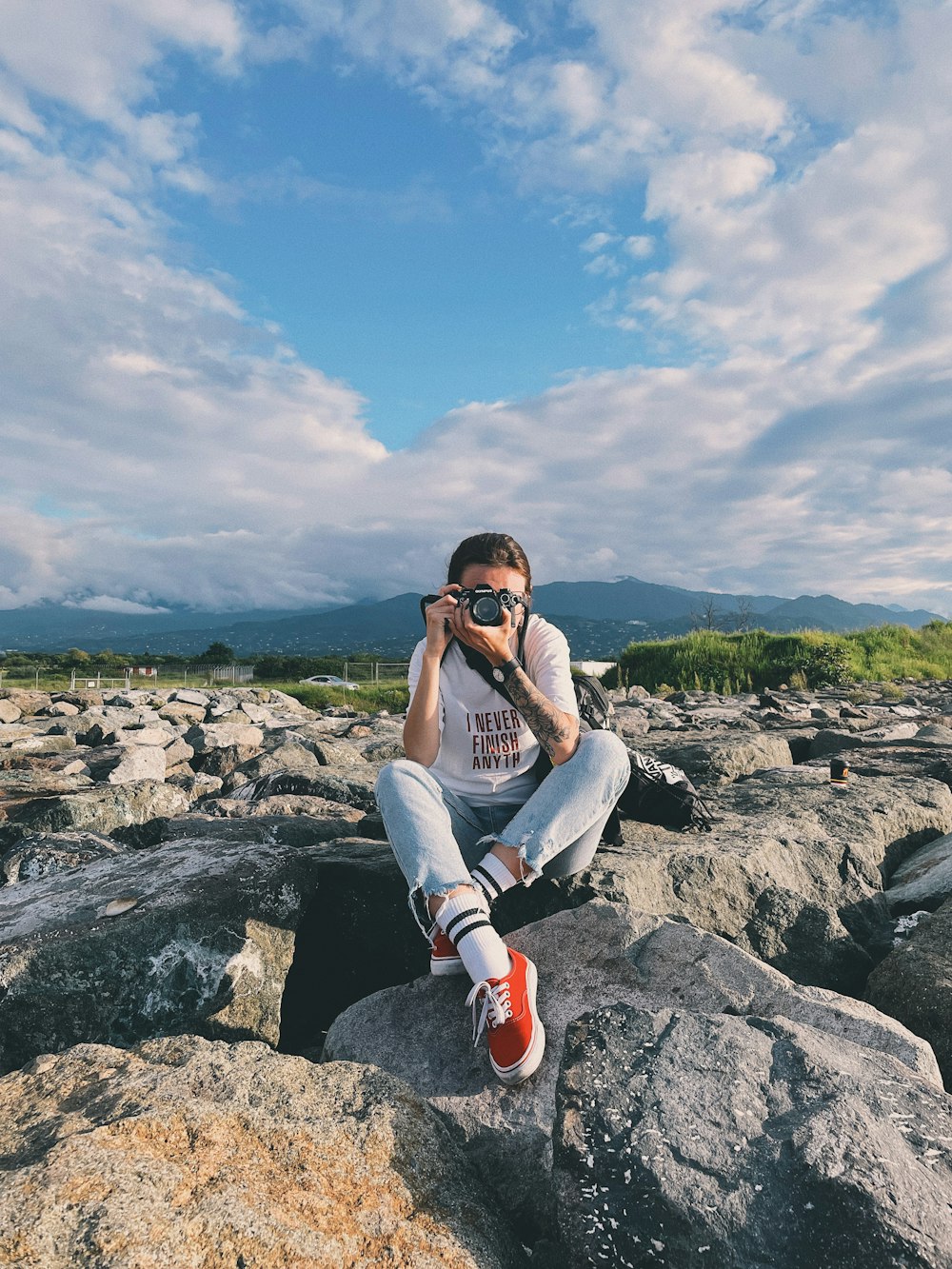 a person sitting on a rock taking a picture