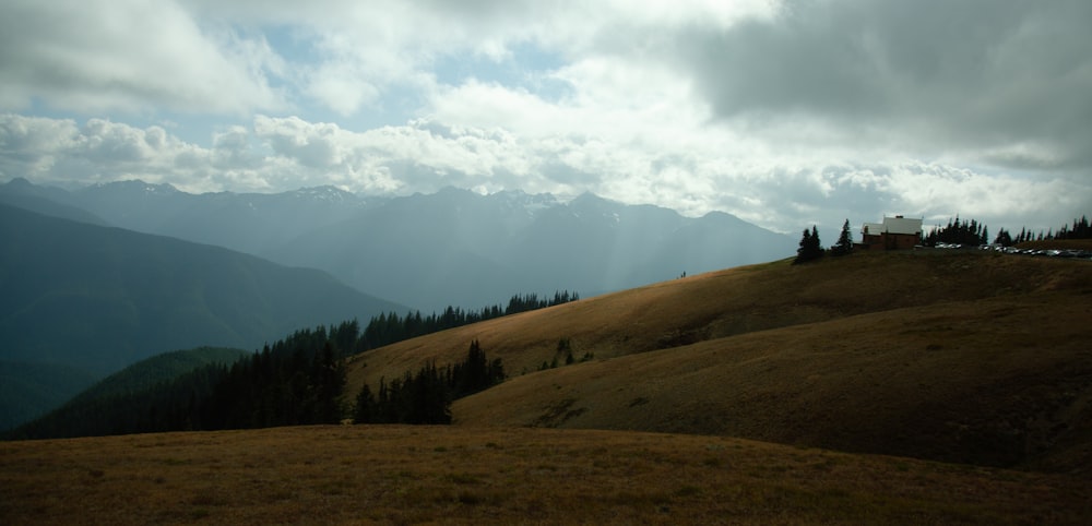 a house on a hill with mountains in the background