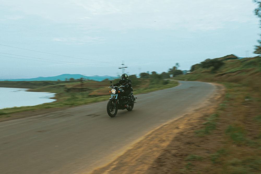 a man riding a motorcycle down a country road