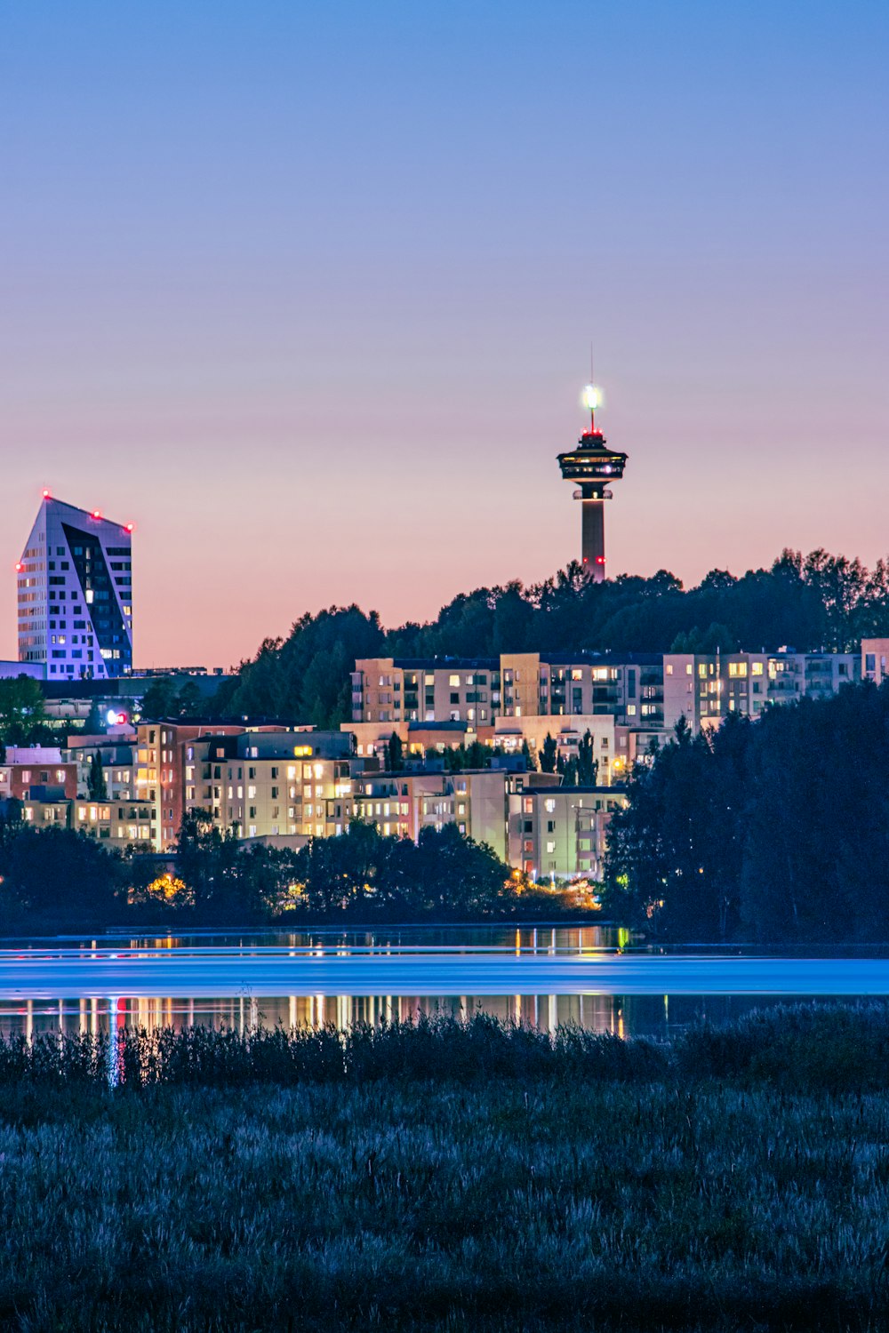 Una vista de una ciudad por la noche desde el otro lado de un lago