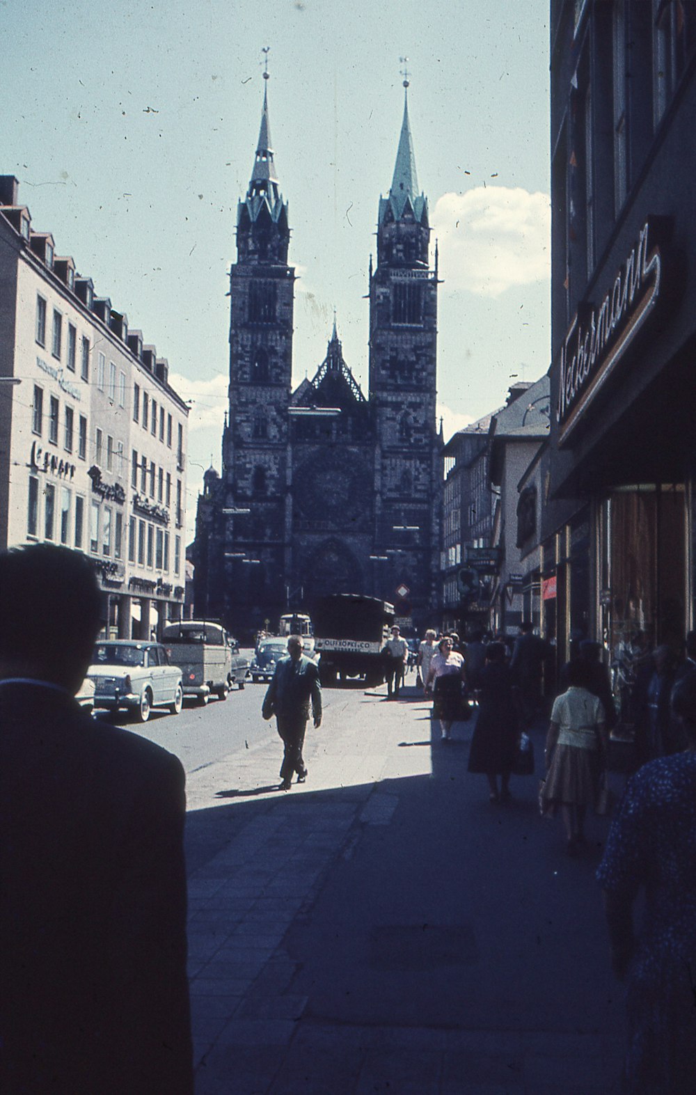 a man walking down a street next to tall buildings