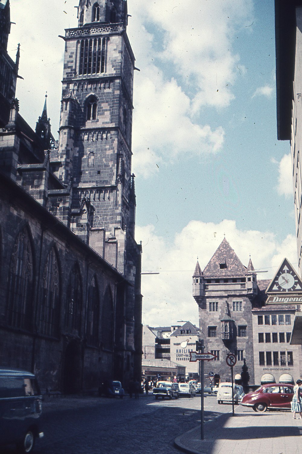 an old photo of a city street with a clock tower in the background
