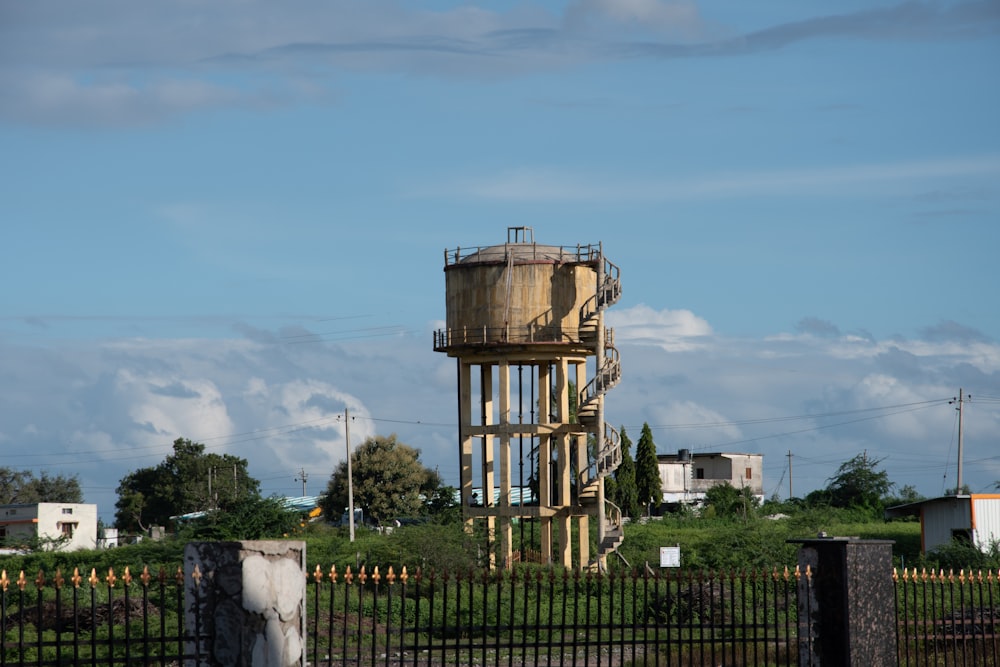 a water tower in the middle of a fenced in area