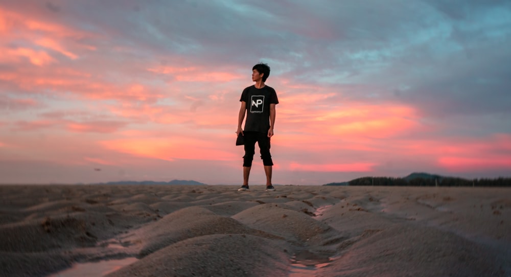 a man standing on top of a sandy beach