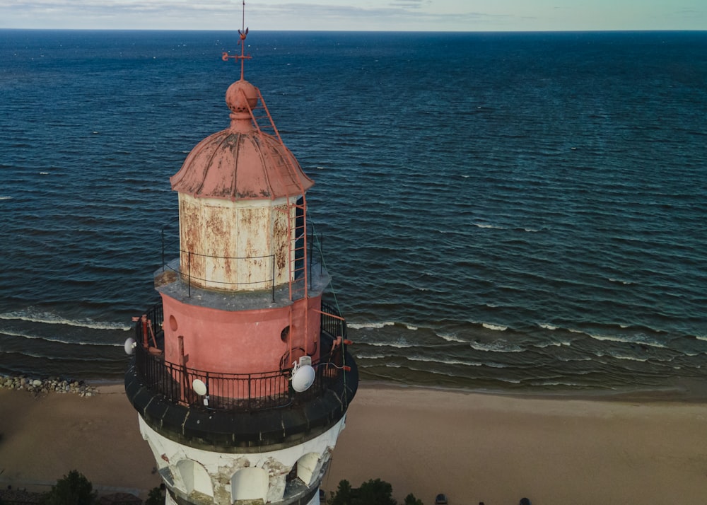 a large light house sitting on top of a sandy beach