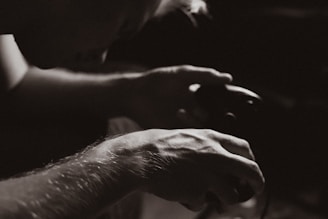 A close-up of a person holding a gaming controller with intense focus.