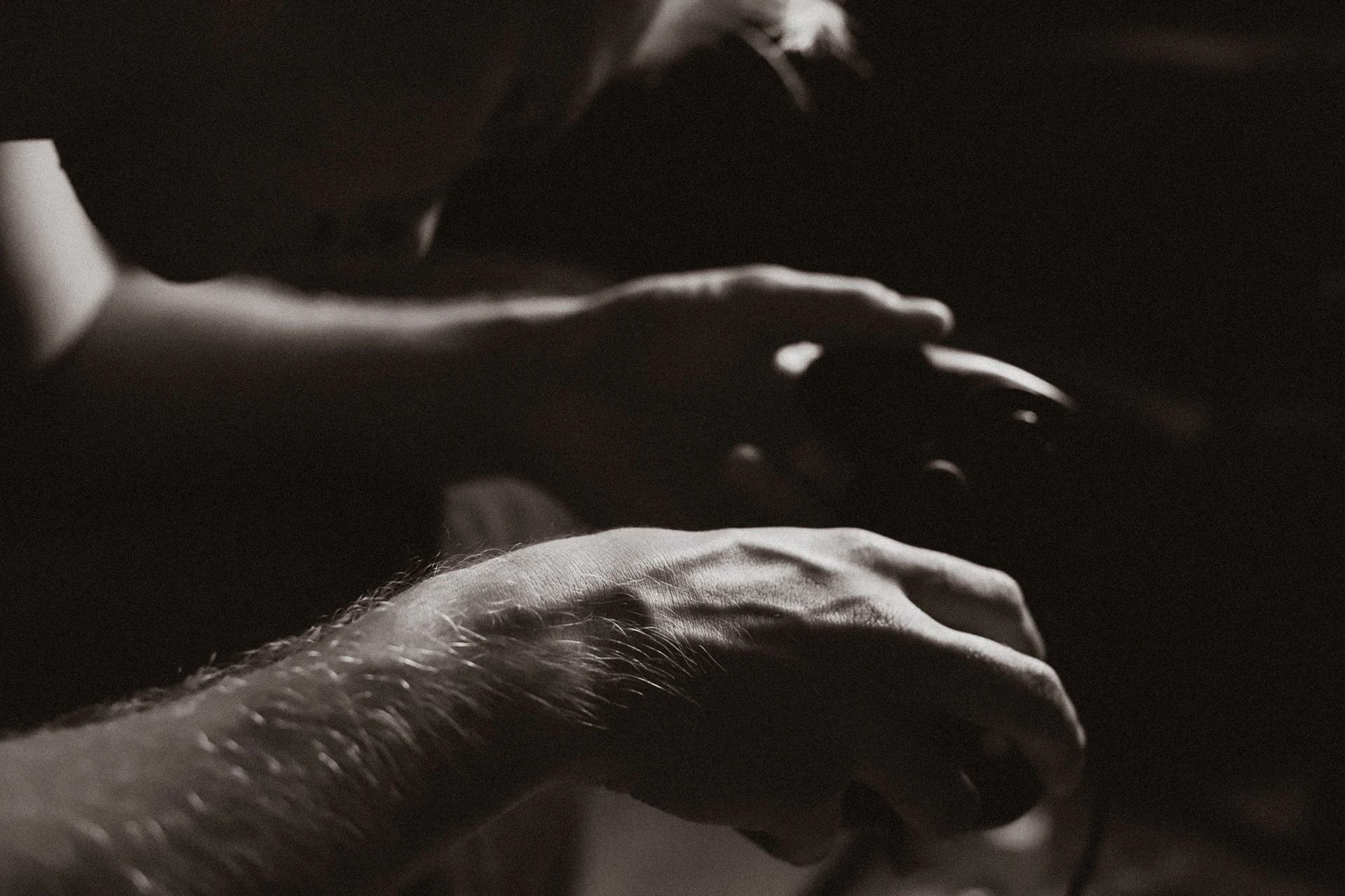 A close-up of a gamer’s hands gripping a controller, with dynamic lighting highlighting their focus during gameplay.