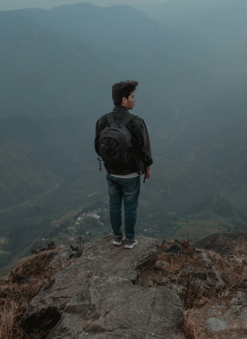 a man standing on top of a mountain with a backpack