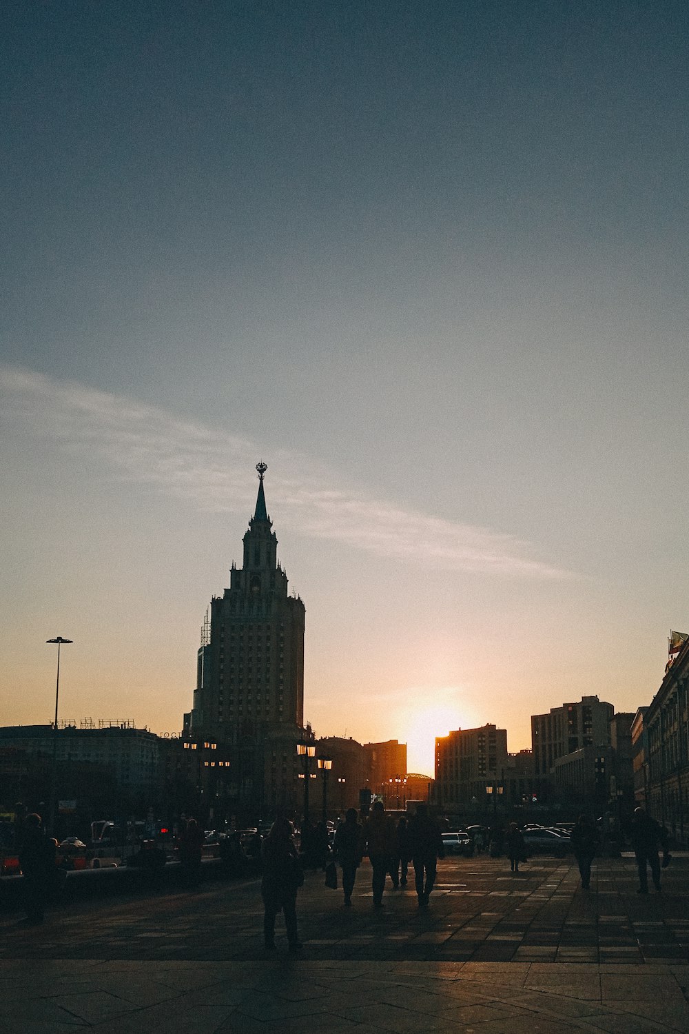 a group of people walking down a street next to tall buildings