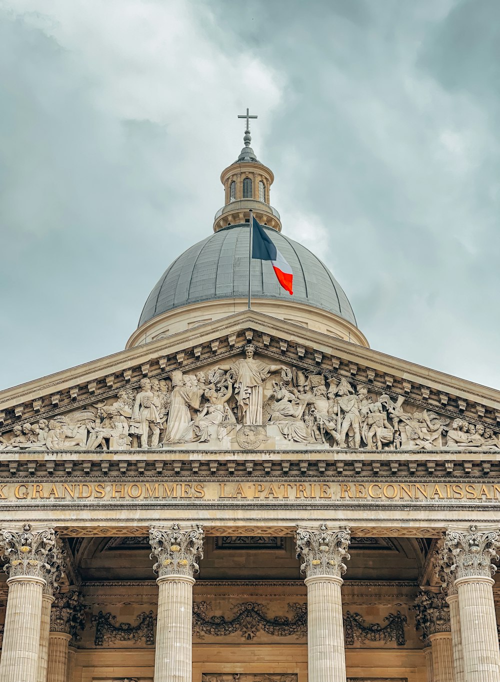 a building with columns and a dome with a flag on top