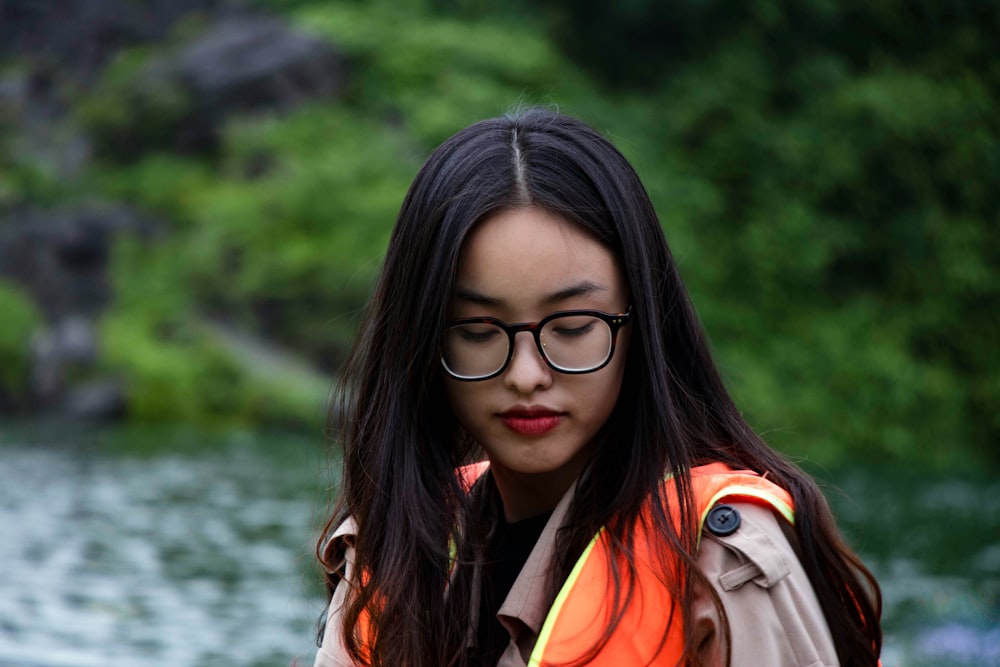 a woman wearing glasses and an orange vest